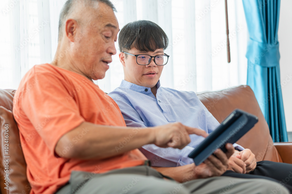 Asian senior man and grandson using tablet smartphone doing a video call in living room, Grandparents and grandson having fun together at home Asian senior man and grandson using tablet smartphone doing a video call in living room, Grandparents and grandson having fun together at home