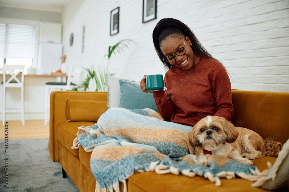 Happy black woman and her dog relaxing on sofa at home. Happy black woman and her dog relaxing on sofa at home.