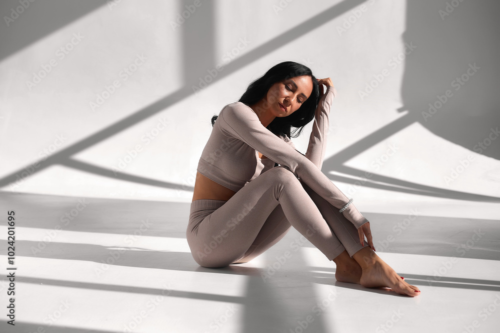 Fototapeta premium Beautiful woman practicing sports, classes in yoga studio. fit figure, acrobatics stretching