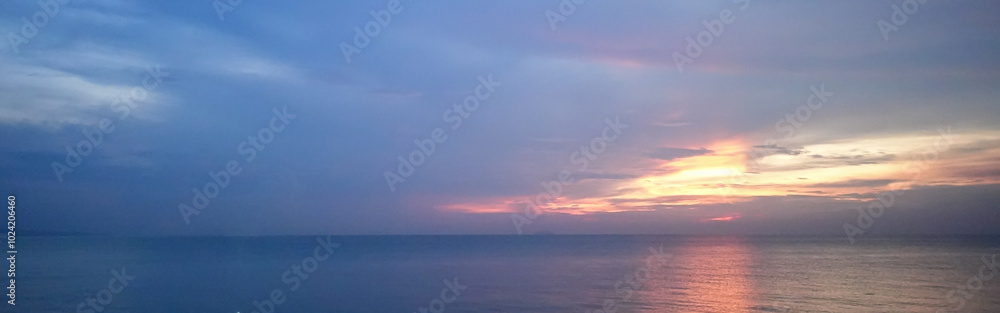 Beautiful blue ocean with a pink and orange sunset in the background Beautiful blue ocean with a pink and orange sunset in the background