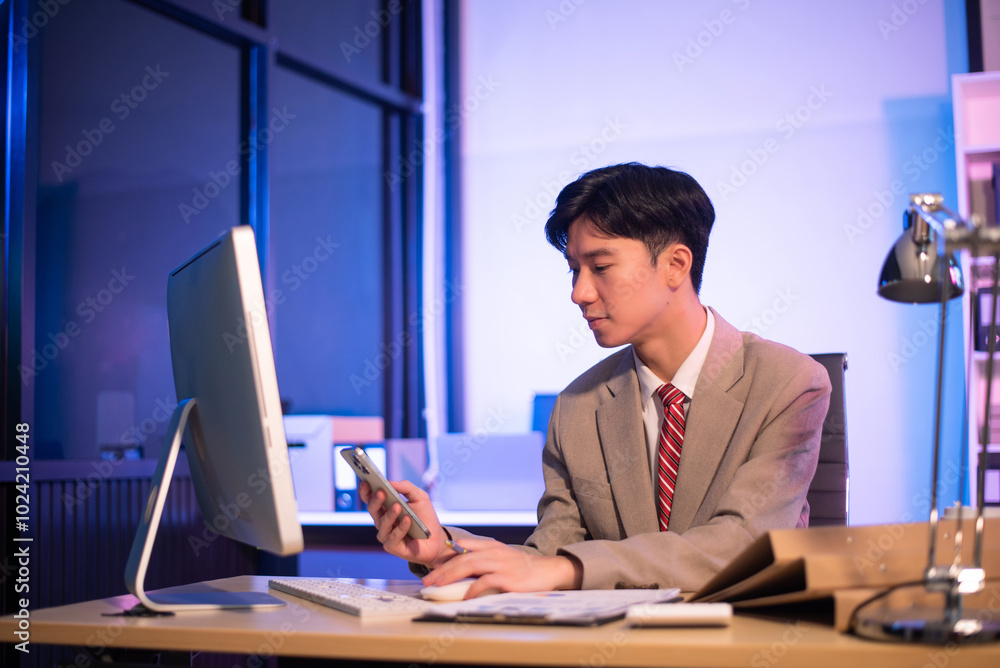 Businessman drinking coffee to get some energy for working overtime sitting at desk using computer and doing overtime Businessman drinking coffee to get some energy for working overtime sitting at desk using computer and doing overtime
