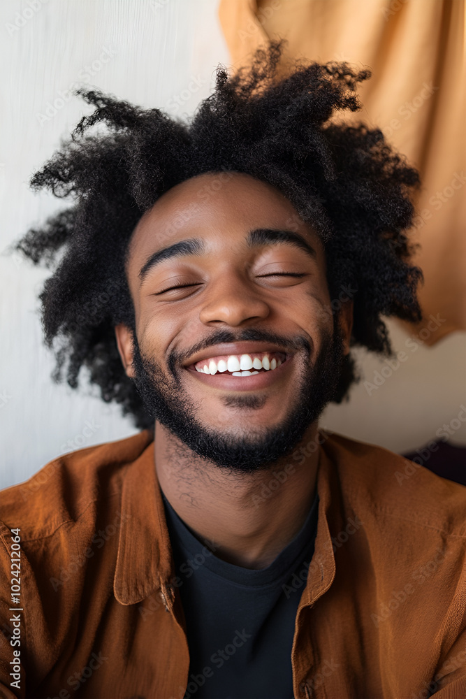 Portrait photo of a young stylish happy African American Carol hipster in close-up, the face of a laughing guy on a light background flooded with sunlight. Portrait photo of a young stylish happy African American Carol hipster in close-up, the face of a laughing guy on a light background flooded with sunlight.