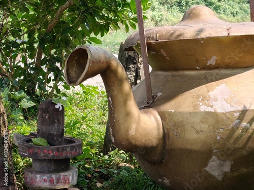 old big size pot pooring water on shibling. photo