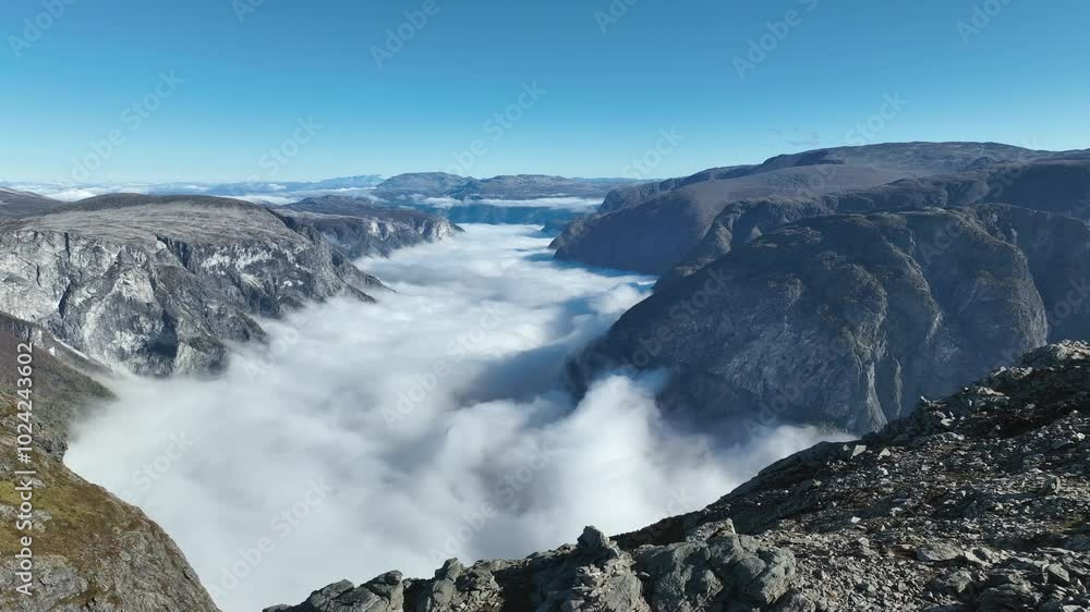 Drone flies sideways close to Bakkanosi rocky top, creating a parallax effect with Naeroyfjord and Breiskrednosi in the distance Drone flies sideways close to Bakkanosi rocky top, creating a parallax effect with Naeroyfjord and Breiskrednosi in the distance