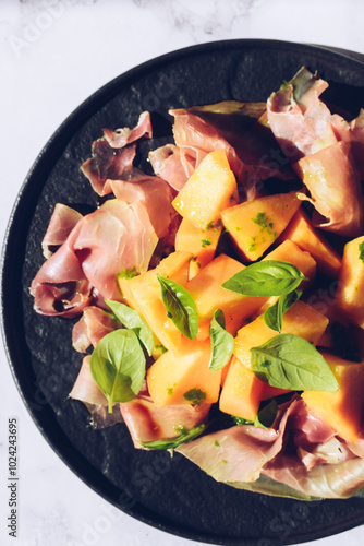 Italian style salad with prosciutto, melon and basil