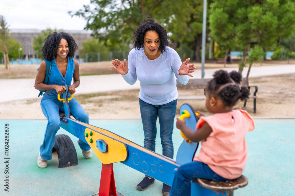 African mother and grandmother spending time at playground with girl African mother and grandmother spending time at playground with girl