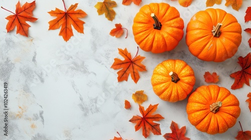 Fall background with orange pumpkins and fall leaves on a light surface photo