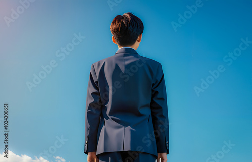 Rear View of Schoolboy Against Blue Sky.
