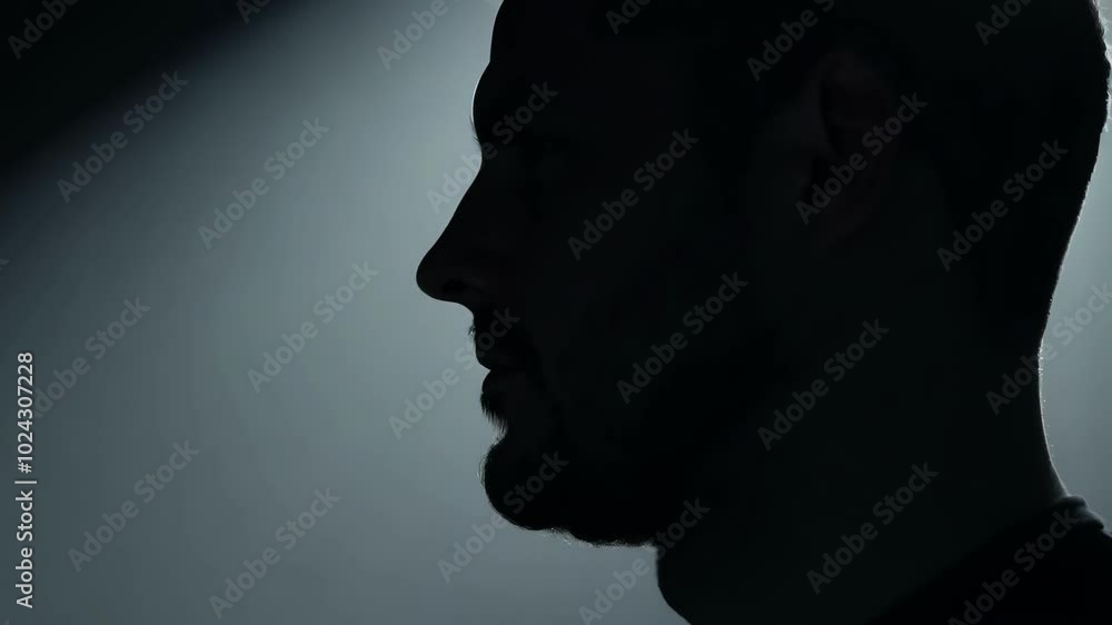 Dramatic silhouette of a man in low light Dramatic silhouette of a man in low light