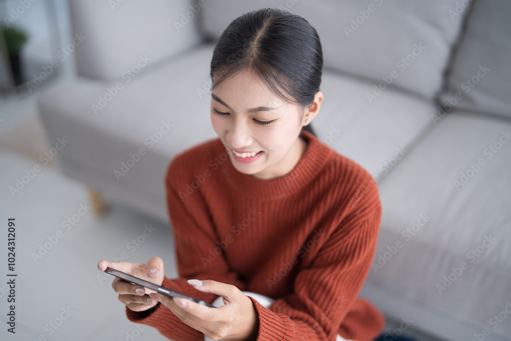 Asian Woman controlling smart home. mobile phone with smart home app in living room. touch screen ai technology. Remote home control system Asian Woman controlling smart home. mobile phone with smart home app in living room. touch screen ai technology. Remote home control system