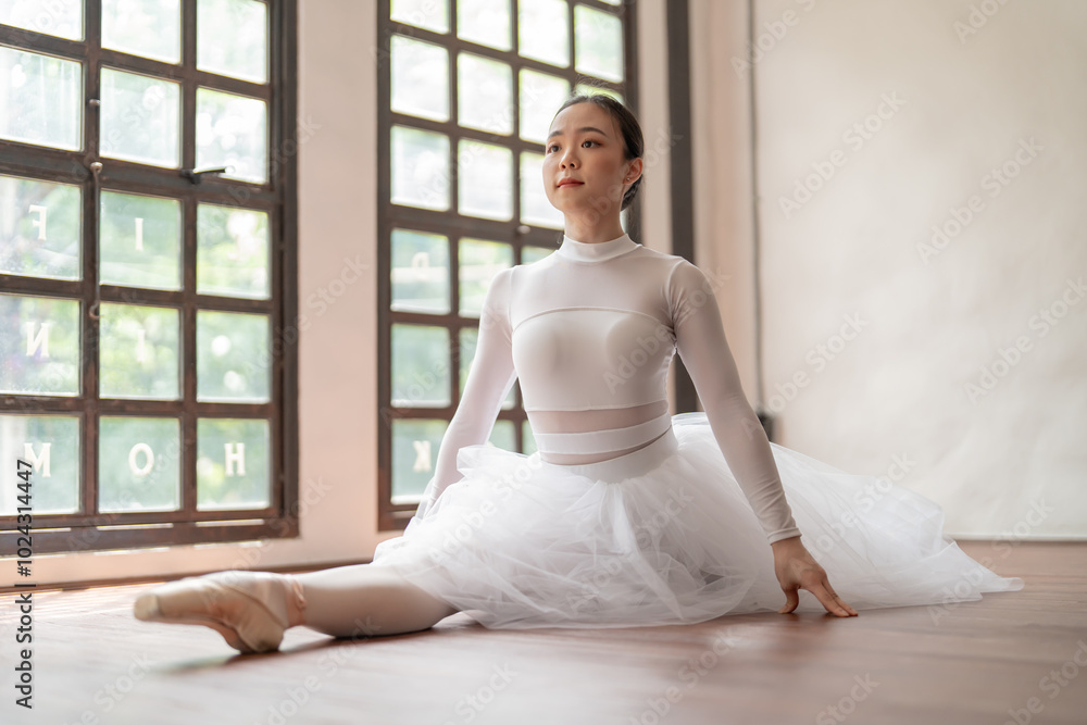 Asian girl ballet dancer gymnastic exercises in studio for body flexibility Ballerina training stretches her leg and prepares for performance practice routine. Asian girl ballet dancer gymnastic exercises in studio for body flexibility Ballerina training stretches her leg and prepares for performance practice routine.