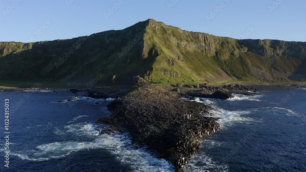 Ascending aerial tilt down revealing the shape of the Grand Causeway's hexagonal basalt formation Ascending aerial tilt down revealing the shape of the Grand Causeway's hexagonal basalt formation