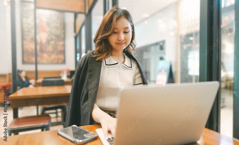 Obraz premium Business freelance asian woman using smartphone and laptop computer at cafe urban lifestyle