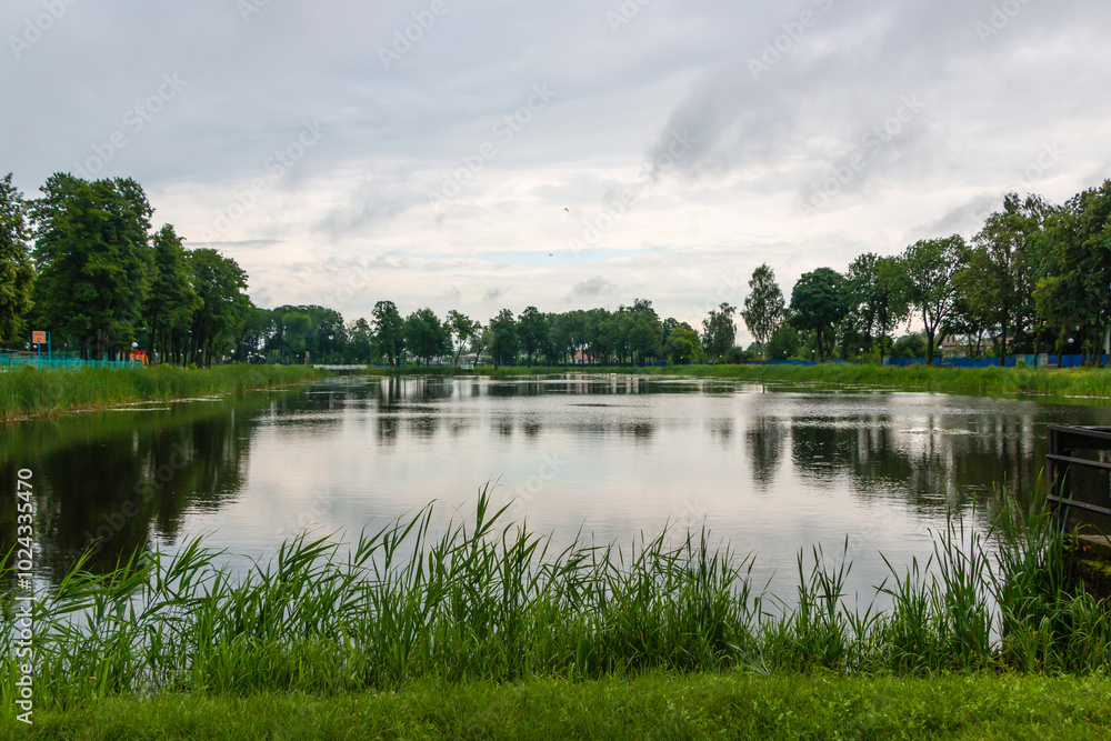 A small lake in a city park on a cloudy summer day in the city of Vetka, Gomel region A small lake in a city park on a cloudy summer day in the city of Vetka, Gomel region