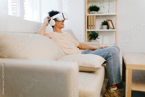 VR headset, relaxation, home, technology, innovation, entertainment, leisure, modern living, young adult, casual setting, comfortable sofa, immersive experience, futuristic design, lifestyle concept