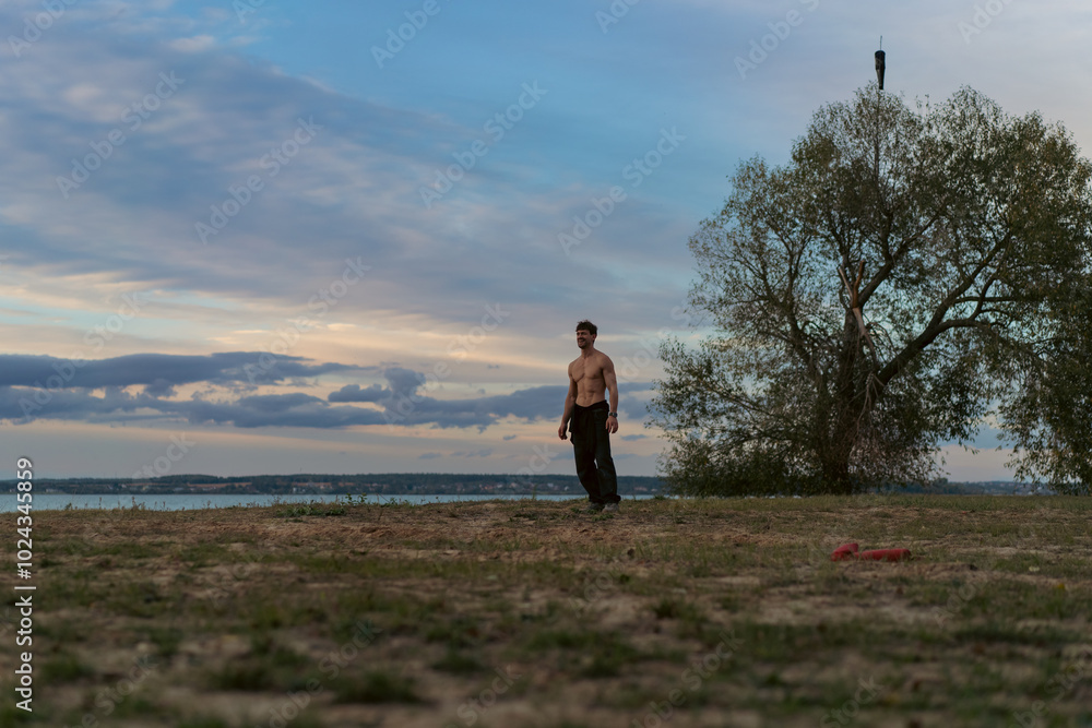 A man against the backdrop of the sunset sky on the shore of a lake. A man against the backdrop of the sunset sky on the shore of a lake.