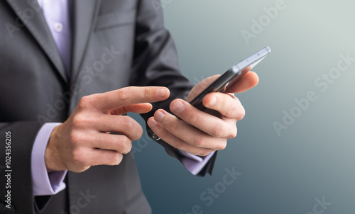 Businessman in the suit is using smartphone