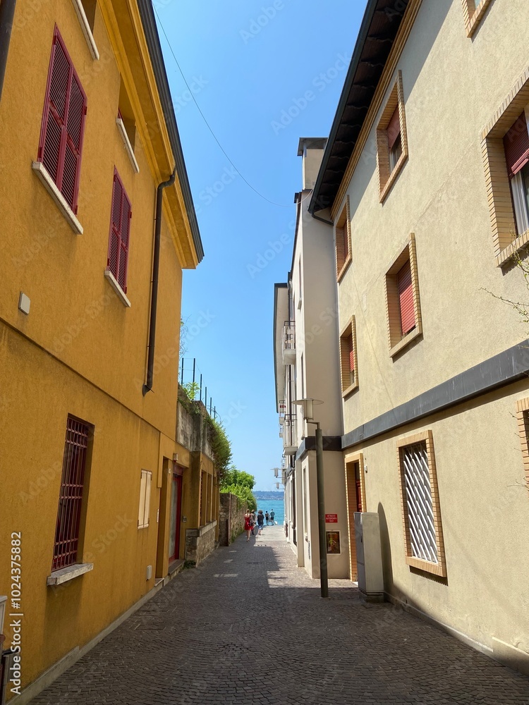 Fototapeta premium A pleasant walk through the quiet narrow streets of an Italian town under the shadow of the ancient buildings surrounding them.