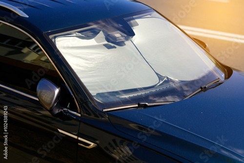 Obraz na płótnie Parked car with windshield sunshade. Reflective car windshield sun shade made of aluminium foil, protect against intense heat and reduce interior temperatures. Heat and UV protection w salonie