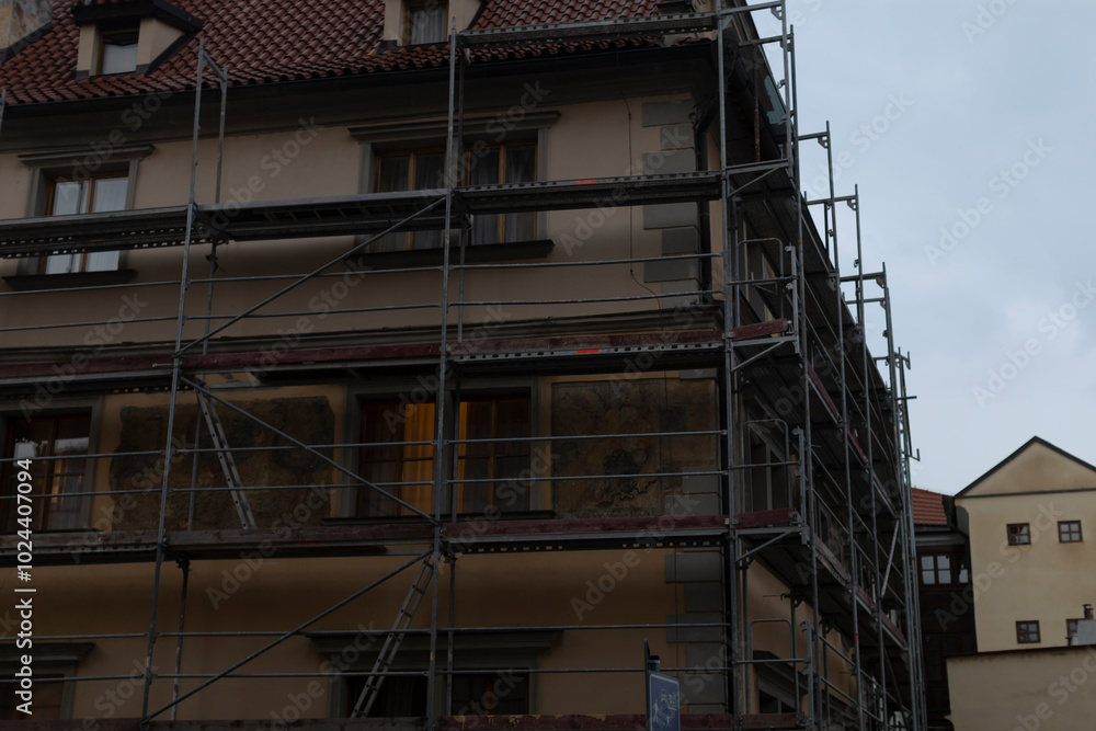 There is a building that has scaffolding situated on one of its sides, indicating that construction or maintenance work is currently underway There is a building that has scaffolding situated on one of its sides, indicating that construction or maintenance work is currently underway