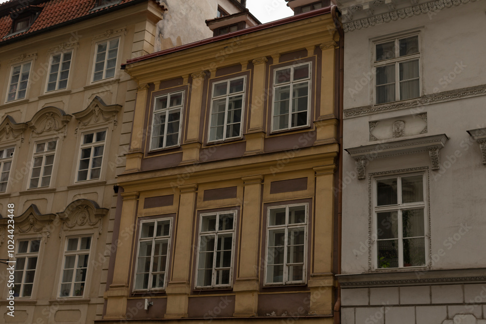 There is a distinctive row of buildings featuring a bright yellow building prominently positioned right in the middle of the scene There is a distinctive row of buildings featuring a bright yellow building prominently positioned right in the middle of the scene