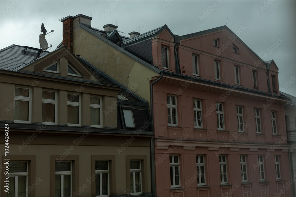 In the scene, theres a long row of buildings set against a backdrop of an overcast gray sky, creating a striking urban atmosphere In the scene, theres a long row of buildings set against a backdrop of an overcast gray sky, creating a striking urban atmosphere