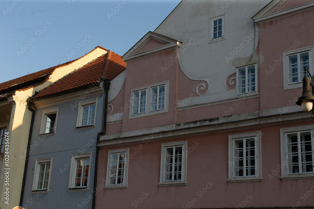 There is a row of several buildings with a distinctive pink building situated right in the middle, creating an interesting visual contrast There is a row of several buildings with a distinctive pink building situated right in the middle, creating an interesting visual contrast