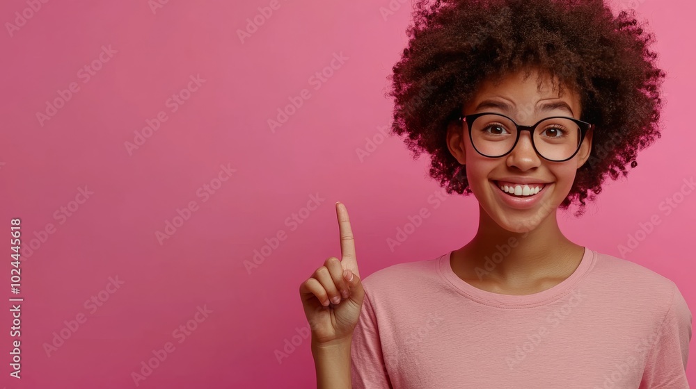 Smiling teen in T-shirt points to blank area. Smiling teen in T-shirt points to blank area.
