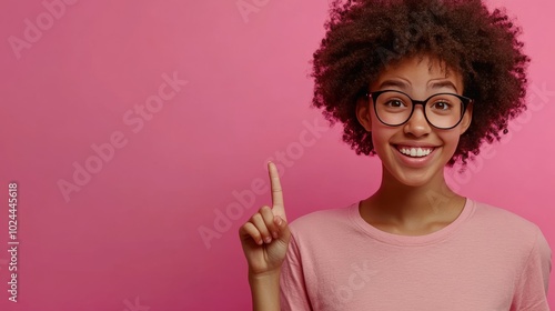 Smiling teen in T-shirt points to blank area. photo