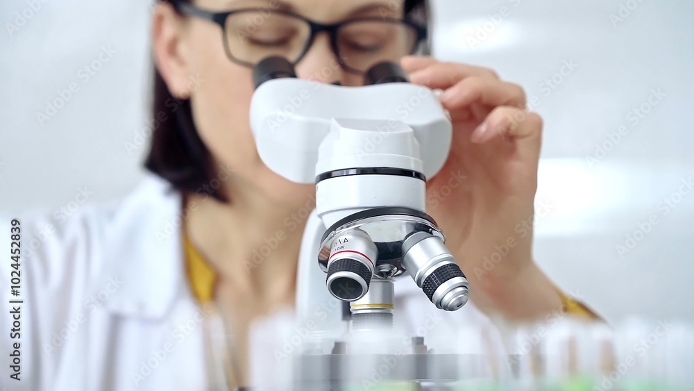 Woman scientist using microscope in laboratory. Microbiology science concept Woman scientist using microscope in laboratory. Microbiology science concept