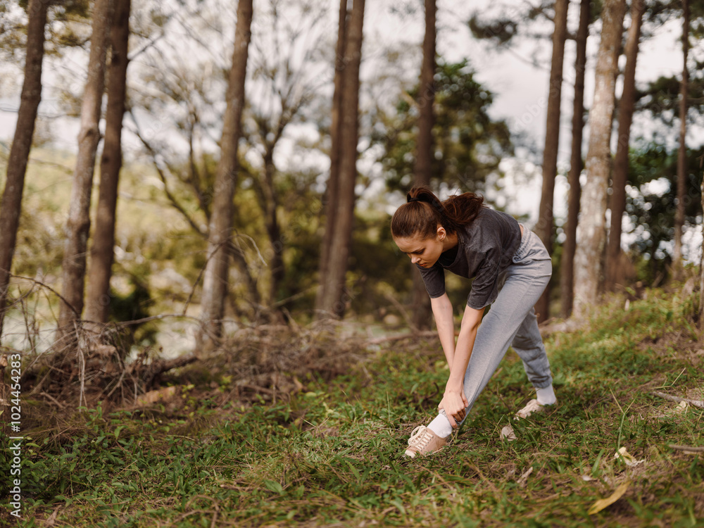 Young woman stretching in a serene forest, wearing comfortable sportswear and focusing on her fitness routine Nature and wellness concept Young woman stretching in a serene forest, wearing comfortable sportswear and focusing on her fitness routine Nature and wellness concept