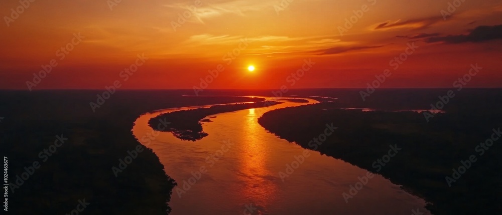 Naklejka premium A winding river cuts through a forest, reflecting the fiery suns