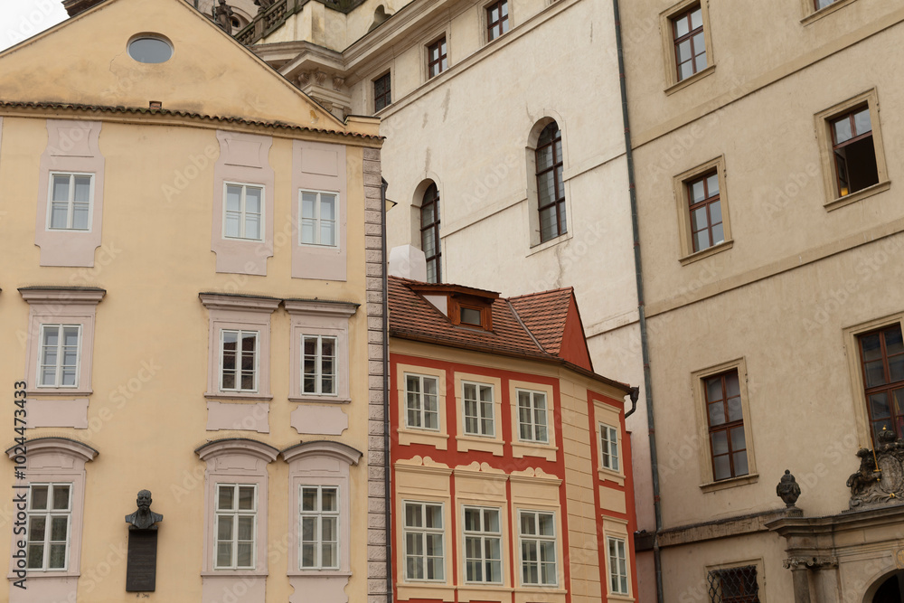 A series of several buildings standing in a row, prominently featuring a striking red building positioned right in the center of the lineup A series of several buildings standing in a row, prominently featuring a striking red building positioned right in the center of the lineup