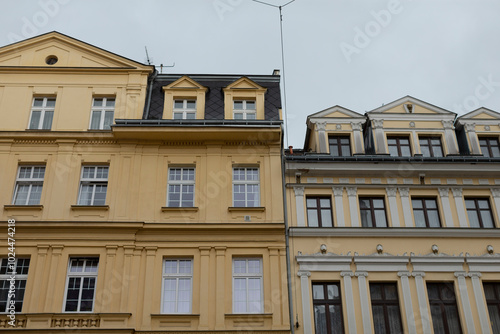 A yellow building that features a distinctive black roof is situated right next to another yellow building that also shares similar architectural elements