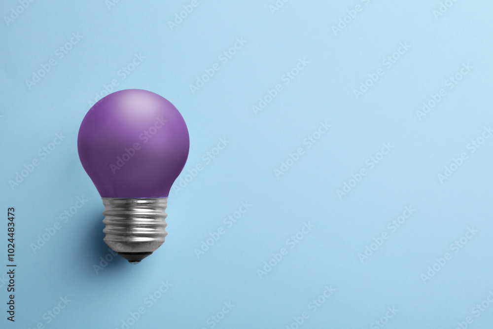 Violet bulb on light blue background, space for text