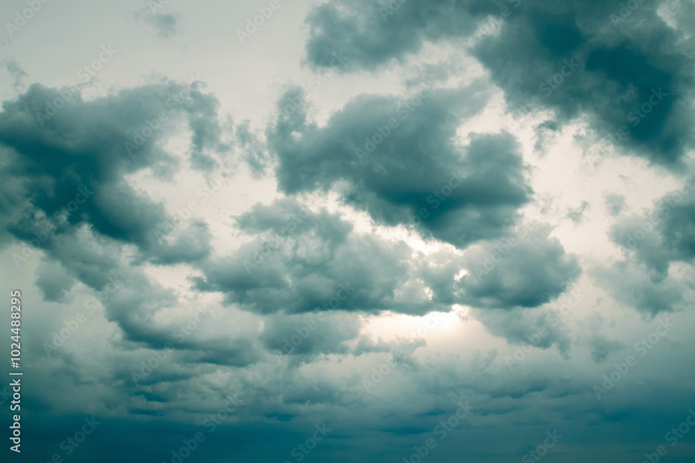 Obraz premium Dramatic sky with turquoise overcast clouds hiding the sun