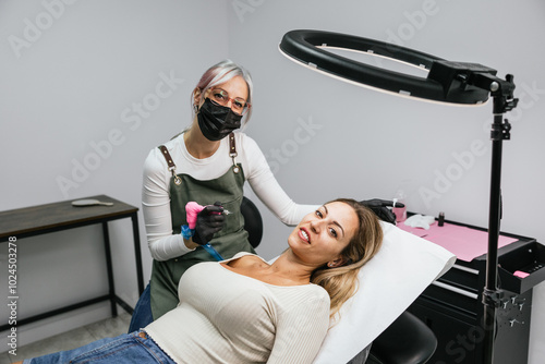 Experienced beautician performs eyeliner micropigmentation on a relaxed female client in a wellequipped, sterile beauty salon setting photo