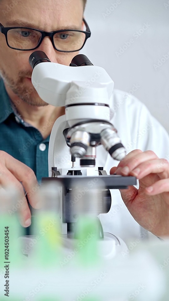 Man scientist using microscope in laboratory. Microbiology science concept Man scientist using microscope in laboratory. Microbiology science concept