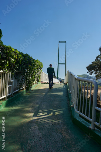 Walkers on the Pobeña cable-stayed bridge over the Barbadún River and the beach photo