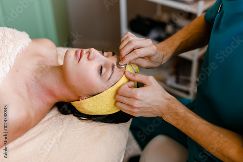 Gua Sha Facial Massage Therapy with Stone in Beauty Studio