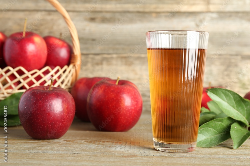 Glass of juice and apples on wooden table Glass of juice and apples on wooden table