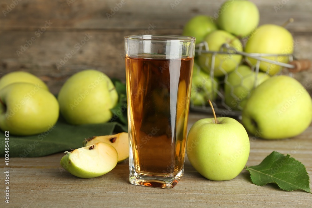 Glass of juice and apples on wooden table Glass of juice and apples on wooden table