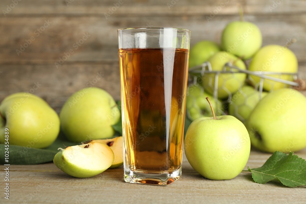 Glass of juice and apples on wooden table Glass of juice and apples on wooden table