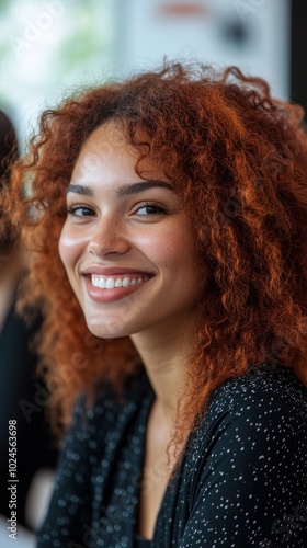 A woman with red hair is smiling and looking at the camera