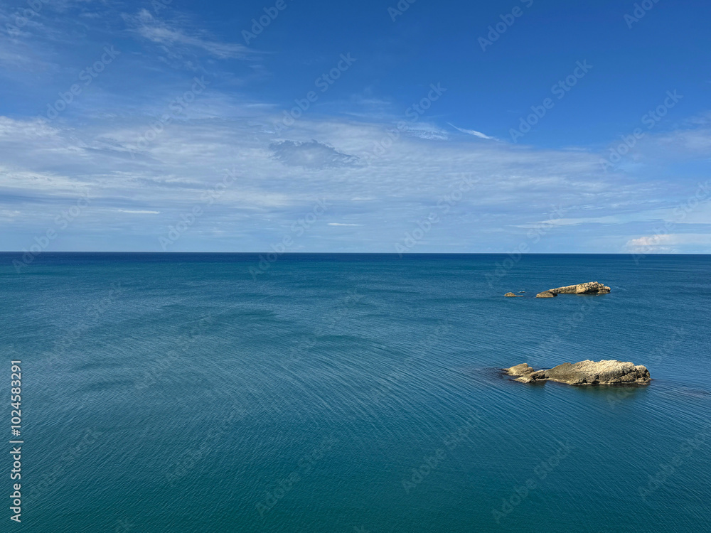 Rocks in sea and clouds in the sky Rocks in sea and clouds in the sky