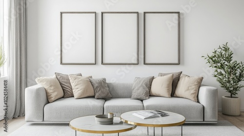 A modern living room featuring a plush, light gray sofa with decorative pillows, a stylish coffee table, and empty frames against a minimalistic wall.