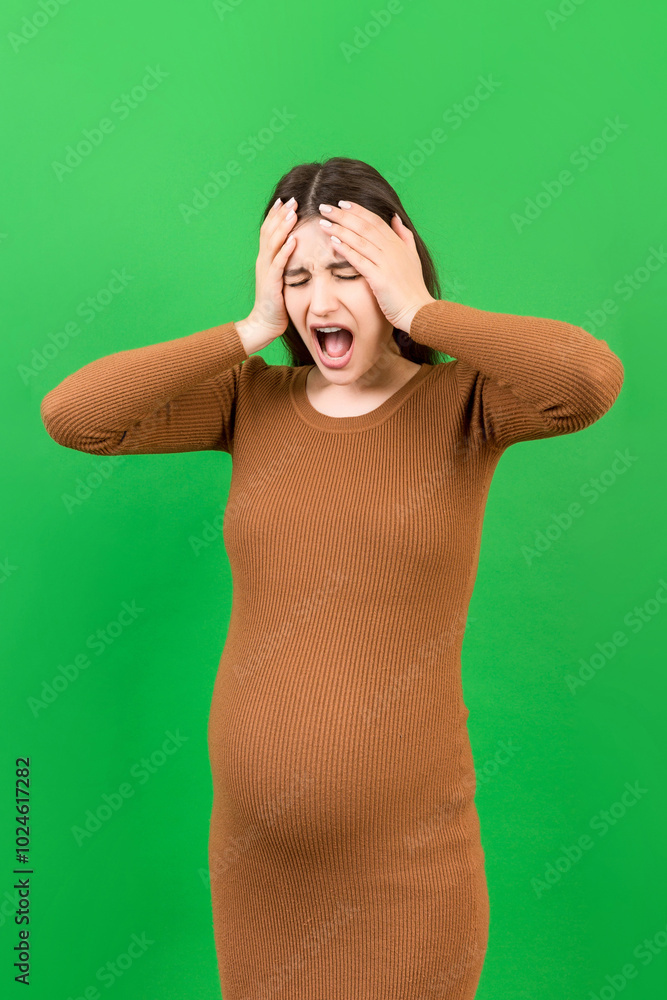 Beautiful young pregnant woman feeling head ache on colored background isolated. Stressed pregnant woman or mother problems Beautiful young pregnant woman feeling head ache on colored background isolated. Stressed pregnant woman or mother problems