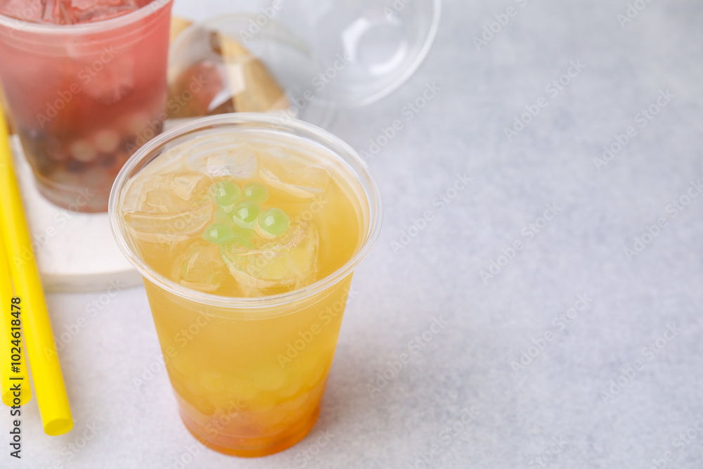 Tasty bubble tea in plastic cups and straws on light table, closeup. Space for text Tasty bubble tea in plastic cups and straws on light table, closeup. Space for text