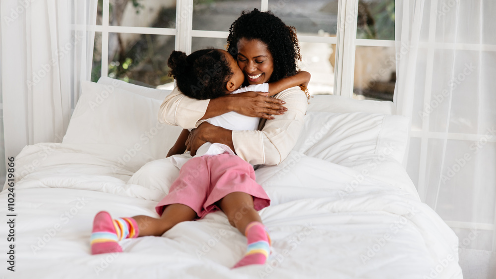 Loving mother hugging daughter in bed Loving mother hugging daughter in bed