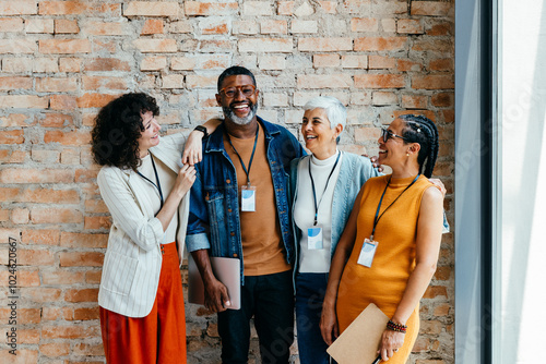 Group of professionals of different ages smiling and standing together photo